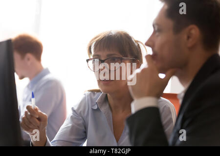 Close up of employees brainstorm working together at pc Stock Photo
