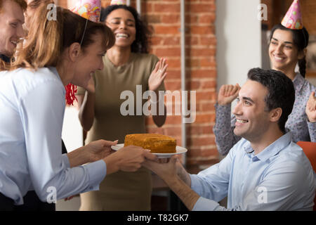 Excited team congratulate colleague in office making birthday present Stock Photo