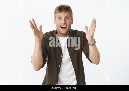 Dude it awesome cannot believe. Portrait of excited happy and thrilled impressed handsome european fair-haired male with bristle shaking hands Stock Photo