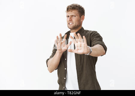Geez take it awat, gross. Portrait of man expressing aversion and dislike step back waving palms in no and refusal, grimacing from reluctanse and Stock Photo