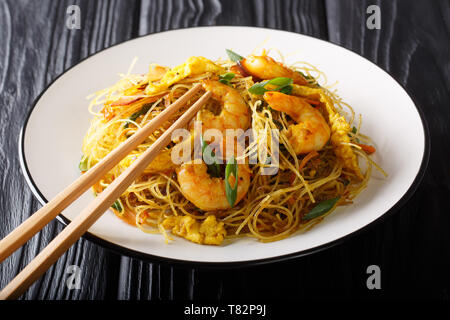 Hot chow Mei Fun rice noodles fried with sausage, shrimps and vegetables close-up on a plate on the table. horizontal Stock Photo