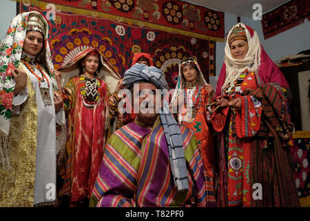 Uzbek man and women wearing traditional silk embroidered costume in the Surkhandarya style in the town of Jarkurgan in Surkhandarya or Surxondaryo Region in Uzbekistan Stock Photo