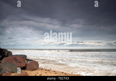 A view of sand, sea, and sky, with breaking clouds, on the Norfolk coast at Happisburgh, Norfolk, England, United Kingdom, Europe. Stock Photo