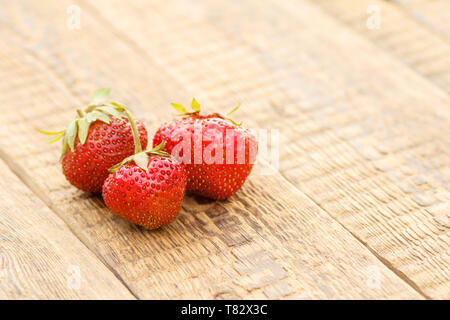 Fresh strawberries on old wooden surface. Sweet ripe strawberries on rustic wooden boards with copy space. Stock Photo