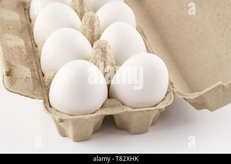 Chicken eggs in a carton, box, tray or container. White background. Stock Photo