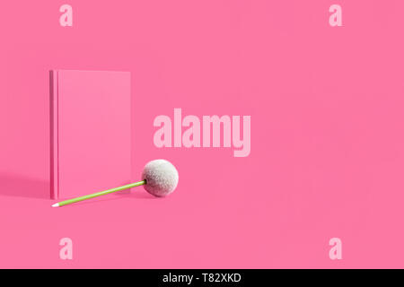 Pink notebook, diary, journal on a matching pink background with green pencil Stock Photo