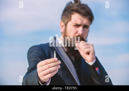 everything in cigarettes Bearded hipster smoking cigarette sky background. Guy cigarette enjoy  nicotine influence. Man with beard mustache hold cigarette. Cigarettes help  us with everything from boredom to anger management Stock Photo