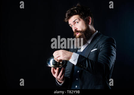 Here is your meal. Something special. Man well groomed bearded gentleman formal suit hold little cloche. Serving and presentation. Elite luxurious. Secret under cloche. Exclusive food hidden cloche. Stock Photo