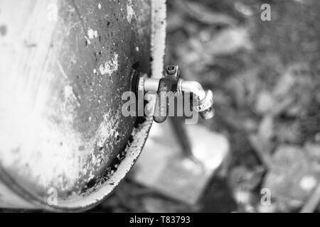 This capture show an old metal oil barrel with a taps, this picture was transformed to black and white to show it as a vintage Stock Photo