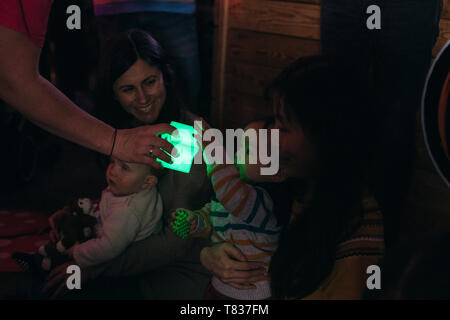 Close up shot of a baby boy having fun in a sensory group with illuminated toys. Stock Photo