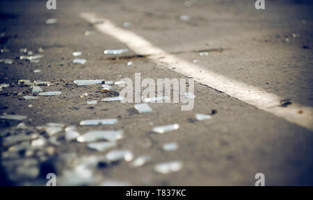 The shards of automotive glass in the accident, lying on the pavement about dividing the solid lines on the roadway Stock Photo