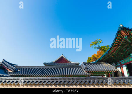Traditional Korean Brick Wall with Black Ceramic Roof and Roof of Traditional Korean Building with blue sky at Seoul, South Korea Stock Photo