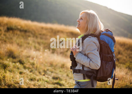 Senior woman is hiking in mountain. Active retirement. Stock Photo