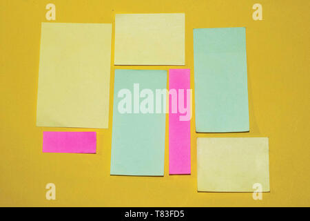 Sticky notes with different size and color on a yellow background. Ready for message and notes Stock Photo