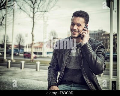 Handsome trendy young man talkiing on cell phone Stock Photo