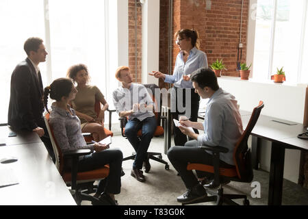 Female boss hold casual meeting brainstorming with employees Stock Photo