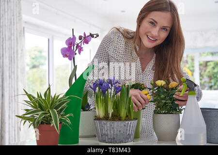 Portrait Of Young Woman Caring For Houseplants Indoors Stock Photo