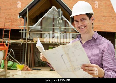 Portrait Of Architect On Building Site Looking At House Plans Stock Photo