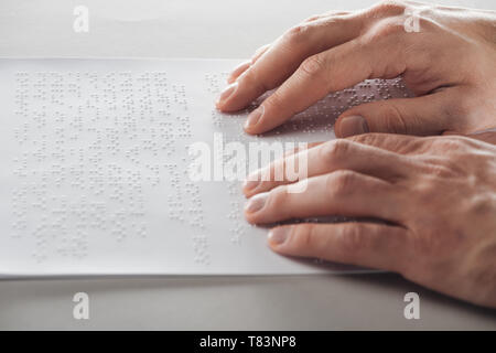 cropped view of man reading braille text with hands Stock Photo