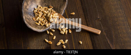 Pine Nuts on Dark Wooden Table. Toasted Organic Healthy Food. Stock Photo
