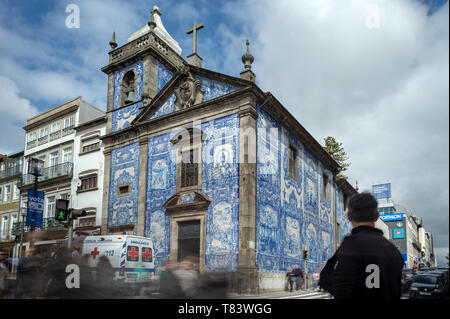 Capela das Almas Church in Porto, Portugal. Blue azulejo tiled exterior facade with blurred people.