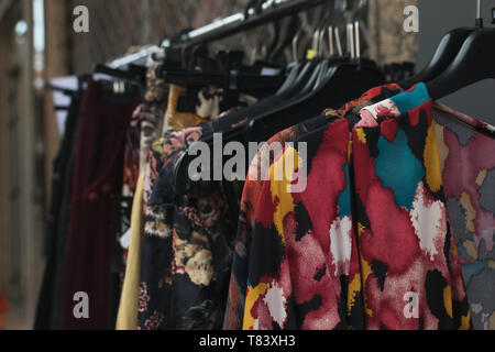 Vintage clothes hanging on a flea market. Second-hand Street shop Stock Photo
