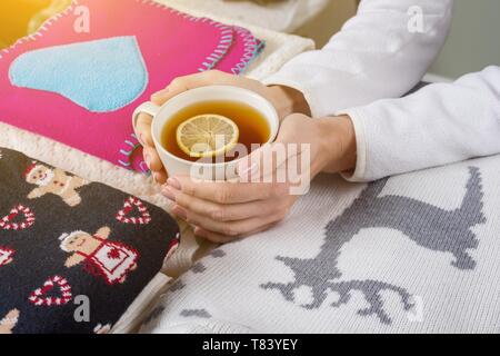 Christmas background winter clothes with traditional patterns, hot tea with lemon. Stock Photo