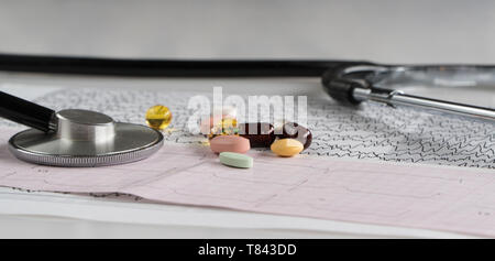 medical stethoscope with pills and cardiogram on a light background Stock Photo