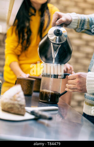 Hipster couple having coffee and talking in kitchen Stock Photo
