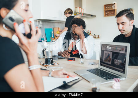 Businessmen and businesswoman using smartphone in loft office Stock Photo