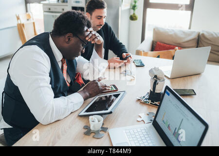 Businessmen using smartphone in loft office Stock Photo