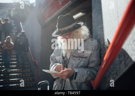 Senior man using digital tablet at entrance to subway, Milano, Lombardia, Italy Stock Photo