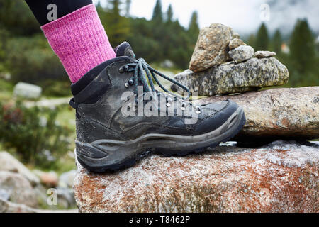 Female hiker stepping onto rock, close up of hiking boot Stock Photo