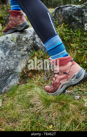 Female hiker stepping onto rock, close up of hiking boots Stock Photo