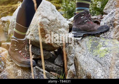 Female hiker stepping onto rock, close up of hiking boots Stock Photo