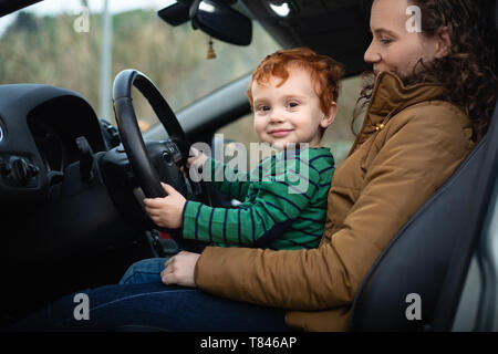 Mother and son at steering wheel of car Stock Photo