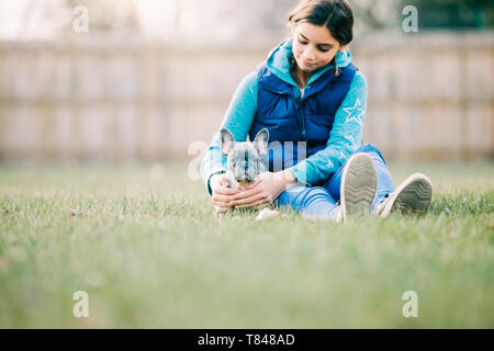 Girl playing with puppy on grass Stock Photo