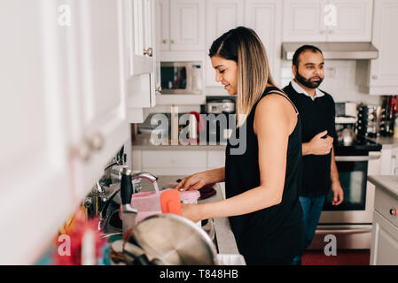 Mid adult couple in kitchen washing dishes Stock Photo