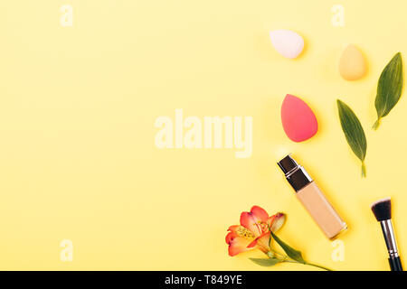 Cosmetic product for smooth face skin foundation cream with tools for professional makeup: synthetic brush and blending sponges, flat lay composition  Stock Photo