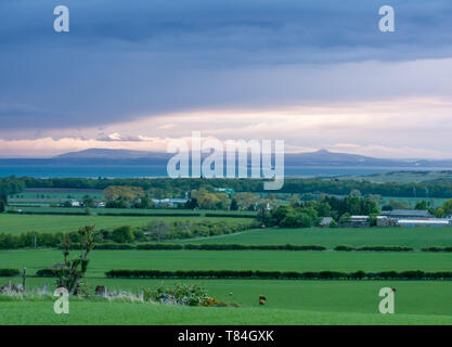 East Lothian, Scotland, UK. 10th May 2019. UK Weather: rain clouds gather and the sky darkens from the West over the county at sunset looking towards the Firth of Forth and the Lomond Hills in Fife Stock Photo