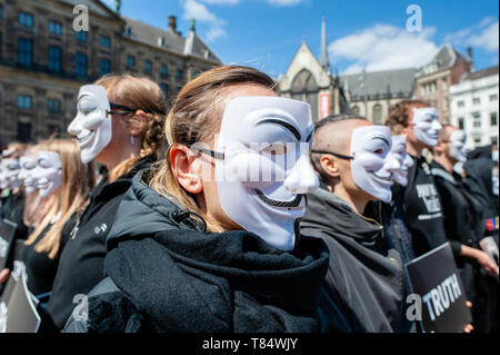 Amsterdam, Netherlands. 111th May 2019. A female vegan activist seen wearing a Guy Fawkes mask during the demonstration. Hundreds of activists gathered at the Dam square in the center of Amsterdam to participate in The Cube of Truth. Anonymous for the Voiceless hosted a 24-hour Cube of Truth in Dam Square, Amsterdam. The Cube of Truth is a peaceful static demonstration similar to an art performance. This demonstration operates in a structured manner that triggers curiosity and interest from the public; the activists attempt to lead bystanders to a vegan conclusion through a combination of loca Stock Photo