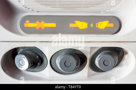 Control panel for air conditioning, with the indication of smoking ban and to keep the safety belts fastened inside a flight cabin of an airplane Stock Photo