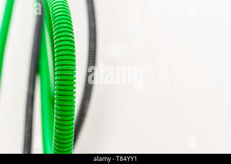 Black and green corrugated bellow conduit tube for electrical wiring Stock Photo