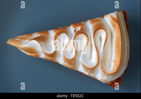 Top View of a Slice of Lemon Meringue Tart on Blue Plate Stock Photo
