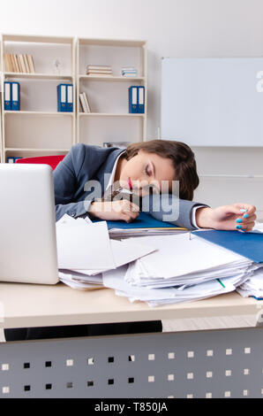 Beautiful female employee unhappy with excessive work Stock Photo