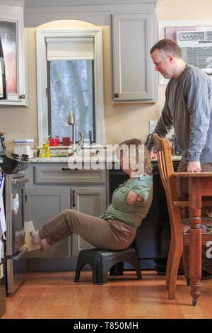 Woman with TAR Syndrome and her husband working in the kitchen together Stock Photo