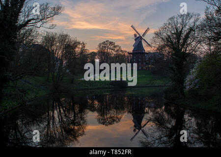 Old windmill in Bremen with water reflections during Sunset/blue hour Stock Photo