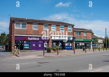 Lloyds and NatWest banks separated by a newsagents on School Road, Tilehurst, Reading, UK Stock Photo