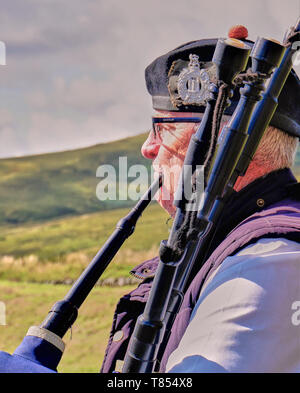 Scottish Bagpiper in the lowland countryside Stock Photo