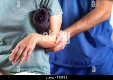 Physical therapist examining patient's arm Stock Photo